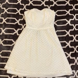 Short white strapless dress.